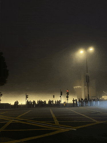 a crowd of people are gathered in a foggy street