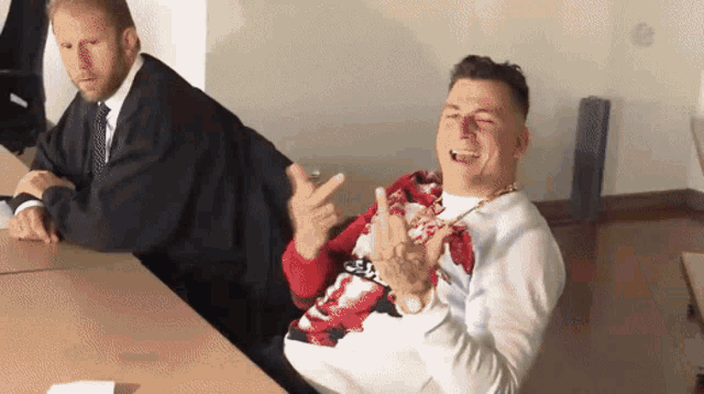 a man in a red and white sweater is sitting at a table