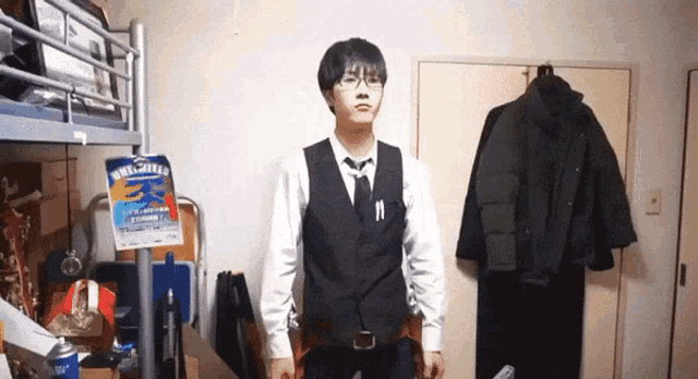 a man in a suit and tie is standing in front of a bunk bed with a poster that says ' a ' on it