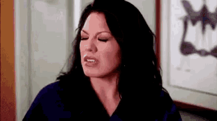 a woman is making a funny face while sitting in front of a picture .