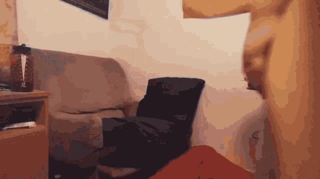 a blurred image of a living room with a couch and a pillow