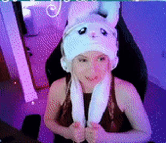 a woman wearing a bunny hat is sitting in a chair and smiling .