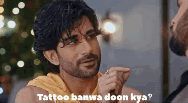 a man with a beard is pointing at another man with the words tattoo banwa doon kya