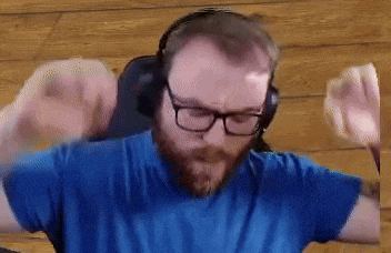 a man with a beard and glasses wearing headphones and a blue shirt .