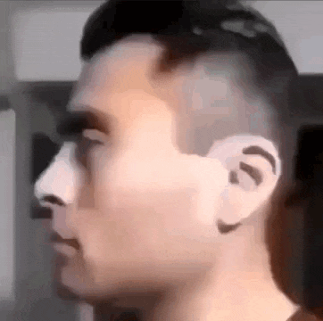 a close up of a man 's face with a shaved head and a nose .