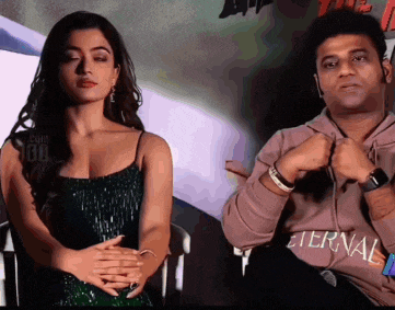 a woman in a green dress sits next to a man in an eternal shirt
