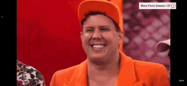 a man wearing an orange hat and an orange suit is smiling