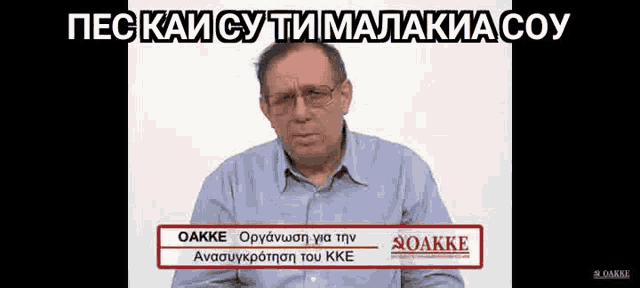 a man wearing glasses and a blue shirt has a sign that says oakke on it