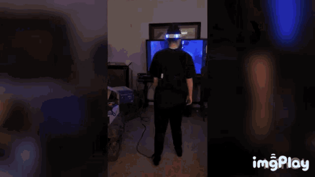 a person wearing a virtual reality headset is being held by another person in front of a television ..