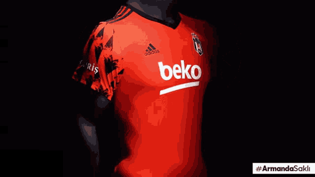 a man is wearing a red adidas shirt with the word beko on the front