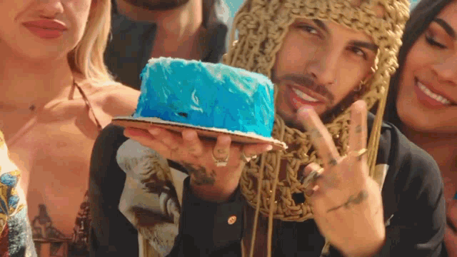 a man is holding a blue cake in his hand