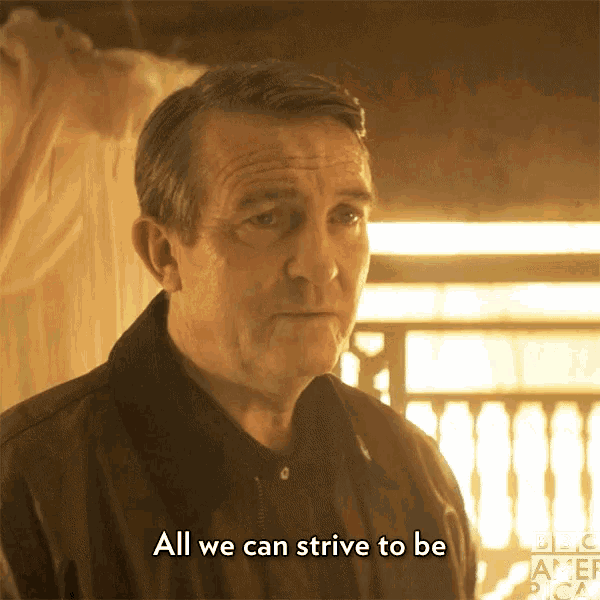 a man says " all we can strive to be " while wearing a brown jacket