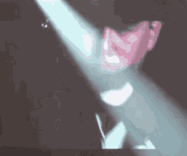 a person is standing in a dark room with a spotlight shining on them .