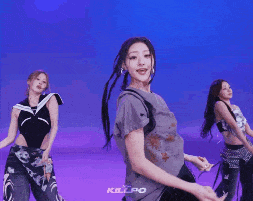 a group of women are dancing in front of a blue background and the word killpo is on the bottom