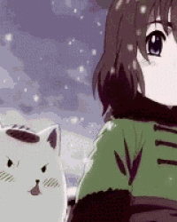 a girl in a green jacket is standing next to a white cat in the snow .