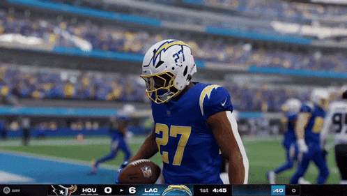 a football player with the number 27 on his jersey is running with the ball
