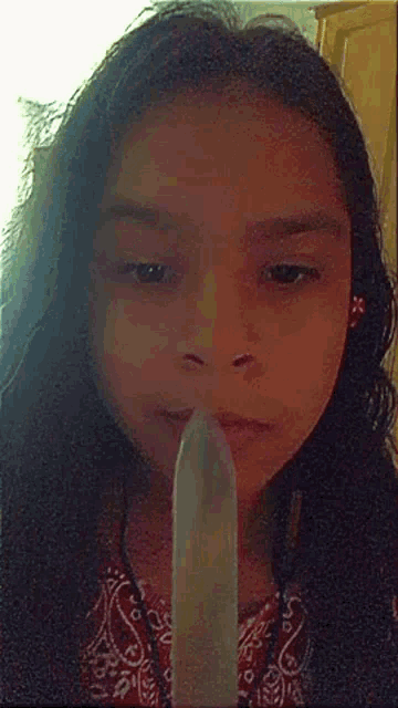 a little girl holding a condom in her mouth