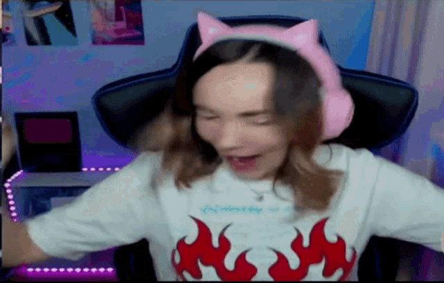 a girl wearing a cat ear headband and a shirt with flames on it