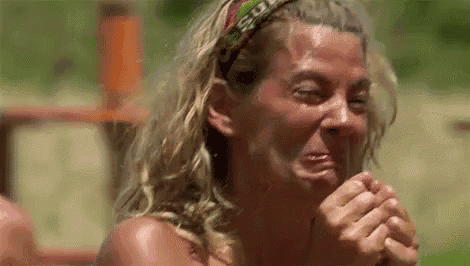 a woman is crying while wearing a headband and holding her hands to her face .