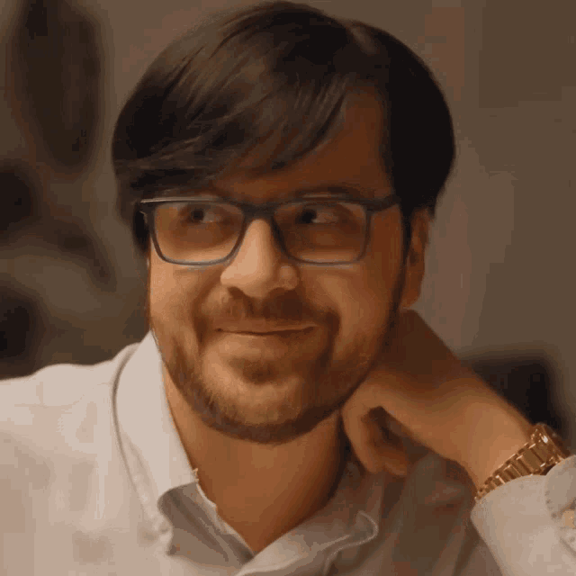 a man with glasses and a beard looks at the camera