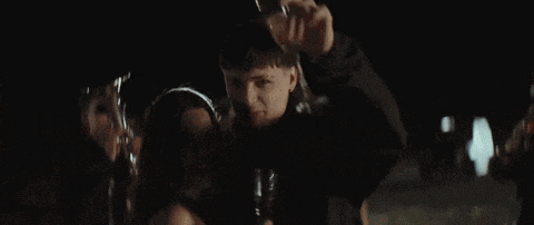 a man and a woman are kissing in a dark room while holding a glass of champagne .