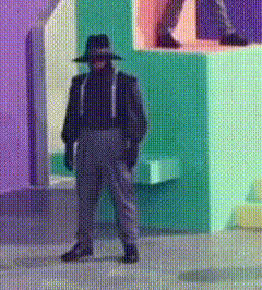 a man wearing a hat and sunglasses is standing in front of a colorful wall