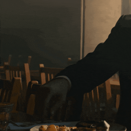 a person is sitting at a table with a plate of food on it