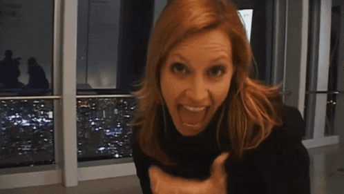a woman in a black turtleneck is making a funny face