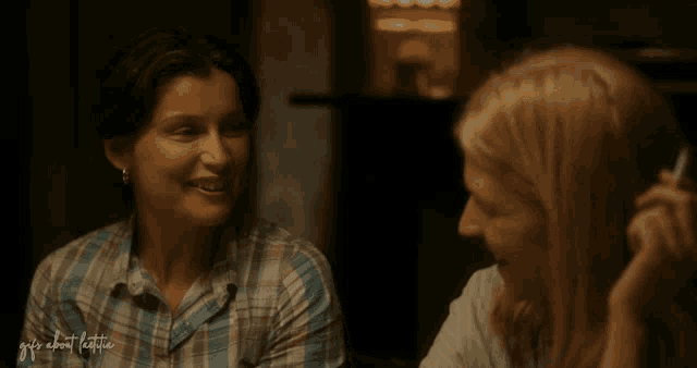 a woman smoking a cigarette next to another woman with the words " guys about latina " written on the bottom right