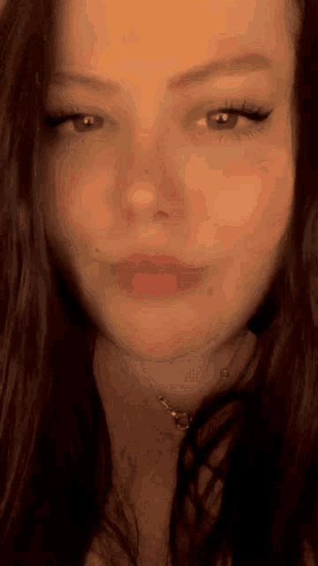 a close up of a woman 's face with a necklace