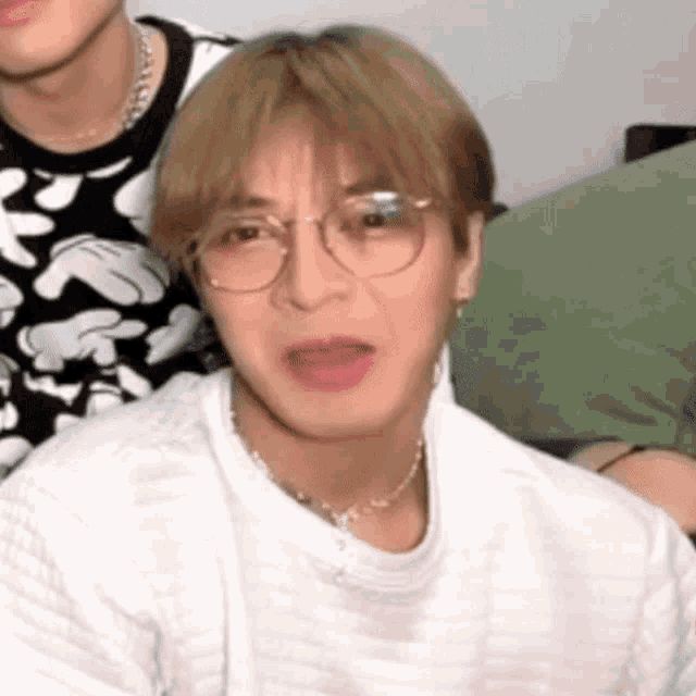 a close up of a person wearing glasses and a white sweater .