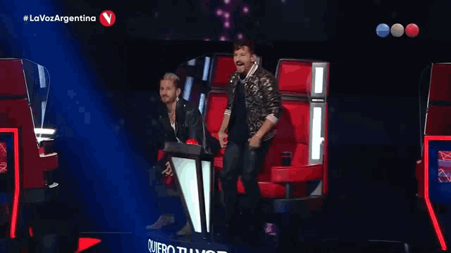 two men standing on a stage with the words la voz argentina on the bottom