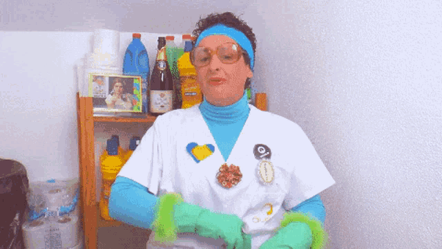 a woman wearing green gloves is standing in front of a shelf with cleaning supplies