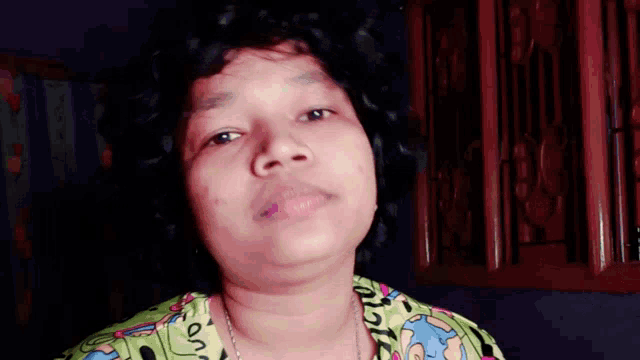 a woman with curly hair is wearing a green shirt that says " on "