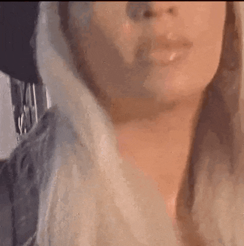 a close up of a woman 's face with long blonde hair and a black jacket .