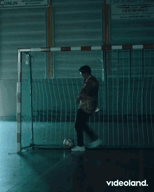 a man kicking a soccer ball in front of a sign that says conijn on it