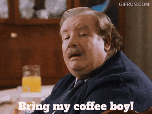 a man sitting at a table with the words bring my coffee boy