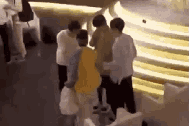 a group of people are standing next to each other in front of a staircase .