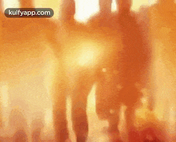 a blurry picture of a person walking in front of a crowd of people .