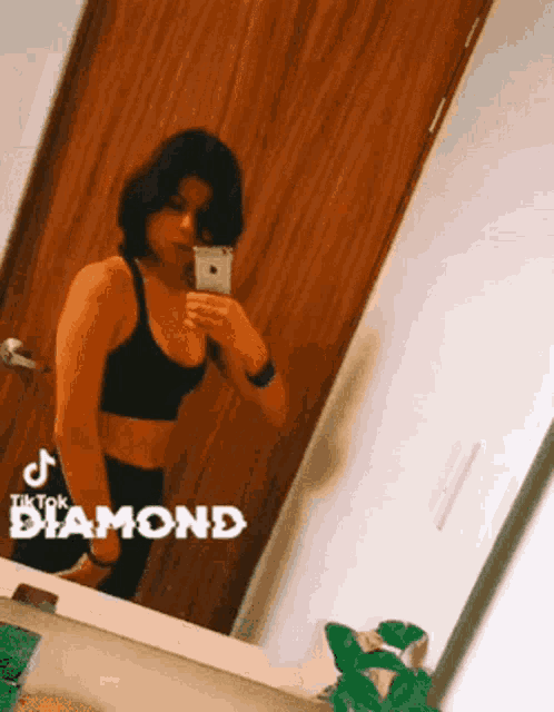 a woman taking a selfie in front of a mirror with tiktok diamond written on it