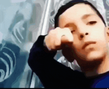 a blurry picture of a boy 's face with his hand on his face