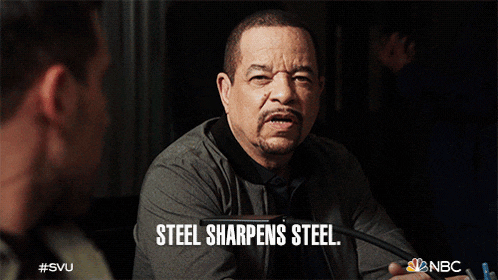 a man sitting at a desk with the words steel sharpens steel written below him