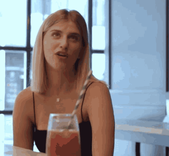 a woman sitting at a table with a glass of juice
