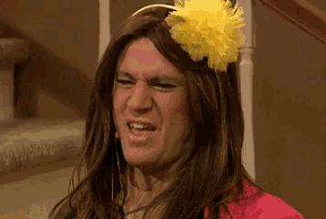 a woman in a wig with a yellow flower on her head