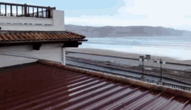 a view of the ocean from a rooftop with a red roof