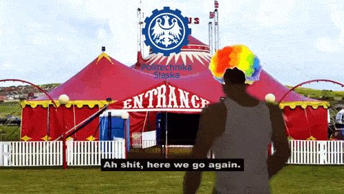 a man in a clown wig is standing in front of a circus tent