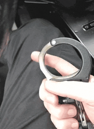 a person is holding a pair of handcuffs between their fingers