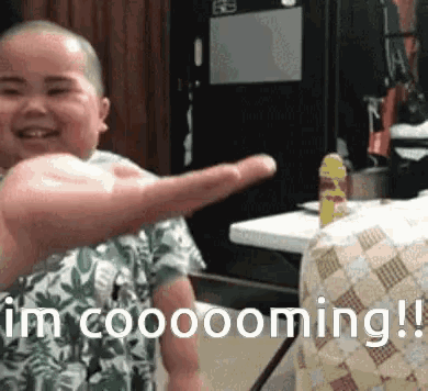 a child is giving a thumbs up with the words " i 'm cooooming " below him