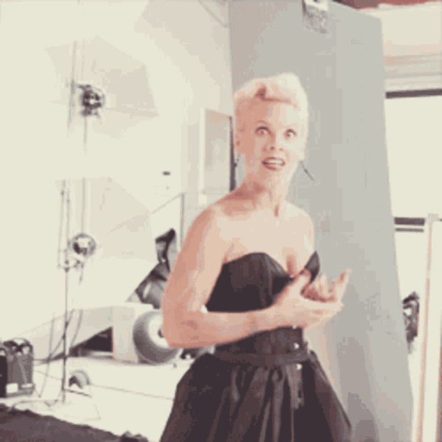 a woman wearing a black corset is making a funny face
