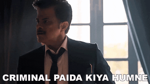 a man in a suit and tie is standing in front of a window with the words criminal paida kiya humne above him